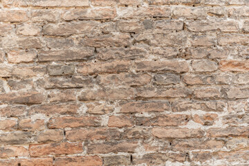 Textured brick wall with varied tones and rustic appeal in an indoor setting