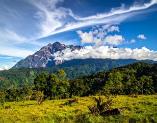 Mountain peak behind green hills with sunny sky and fluffy clouds