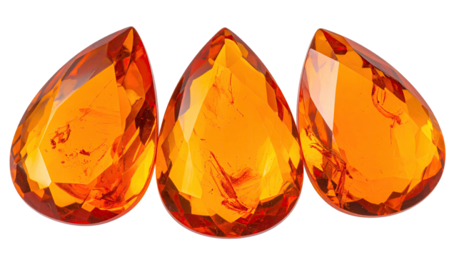 Three orange teardrop gems, faceted and shiny on black background