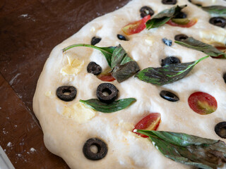 Homemade Focaccia Bread Dough with Fresh Toppings on Wooden Board - Italian Flatbread Preparation Before Baking