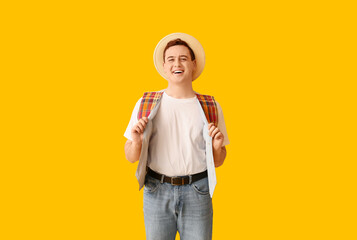 Young man in hat on yellow background