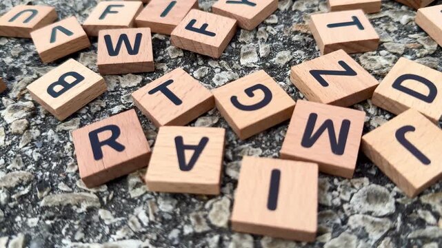 Wooden alphabet blocks scattered on a textured surface