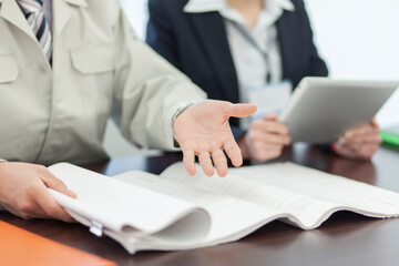 打ち合わせをする作業着姿の男性とビジネスウーマン 