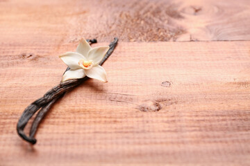 Beautiful vanilla flower and sticks on wooden background
