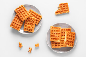 Plates with tasty Belgian waffles on blue background