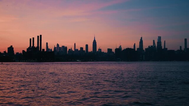 Manhattan Skyline at Dusk with Glowing Skyscrapers and Sunset Reflections