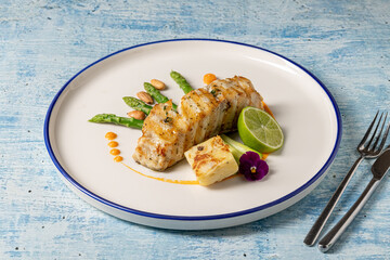 Gourmet grilled white grouper fillet served with asparagus, almond, and lime
