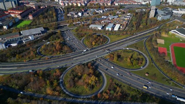 Complex highway interchange with cars traversing roads in Berlin. Bird's eye view drone camera pointing down. Best aerial view flight fly reverse drone
