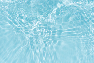 Blue water with ripples on the surface. Defocus blurred transparent blue colored clear calm water surface texture with splashes and bubbles. Water waves with shining pattern texture background.