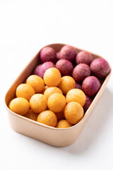 Deep fried sweet potato balls in paper box on white background, Thai street food snack