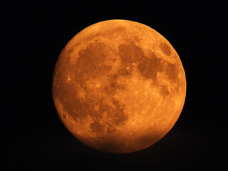 blurred full moon in the dark sky behind clouds