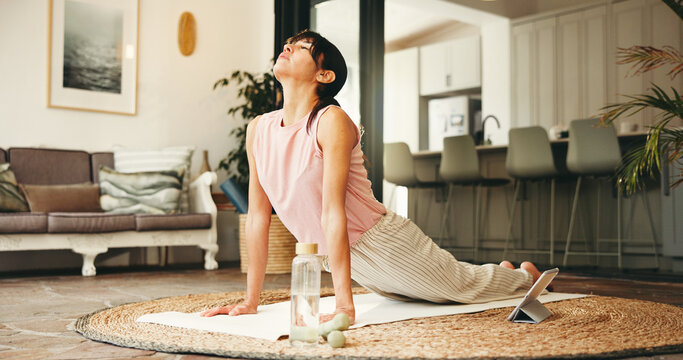 Woman, yoga and stretching with tablet for online class, tutorial or fitness exercise in home. Active, female person or yogi with technology, cobra pose or balance for virtual lesson or zen in house - Powered by Adobe