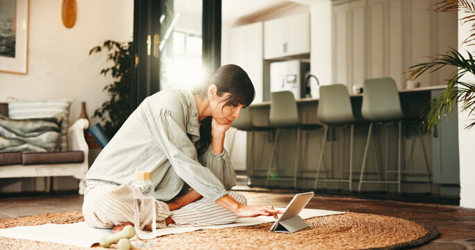 Exercise, tablet and yoga with woman on floor in living room of home for online holistic course. App, fitness and wellness with mature yogi person in apartment for virtual health class or tutorial - Powered by Adobe