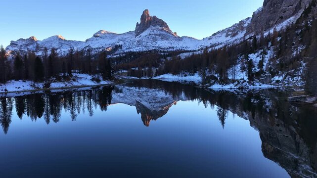 Aerial View of snowy Alpine lake in the Italian Dolomites in winter with snowcapped peaks, drone view of Lake Federa, Dolomites, Italy. Lake Federa and the Cortina valley. 