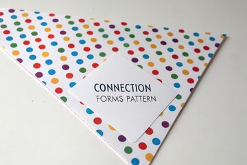 Fototapeta premium A white slip of paper with text Connection Forms Pattern on a colorful dotted background