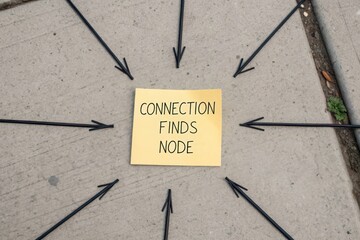 An overhead shot of a sticky note reading Connection Finds Node with converging arrows