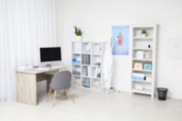 Blurred view of medical office with doctor's workplace and shelf units