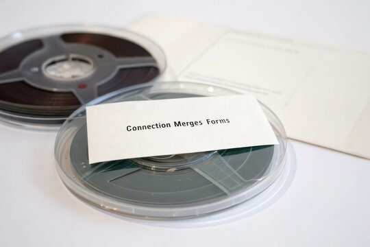Close up of a vintage reel to reel data tape with a Connection Merges Forms label