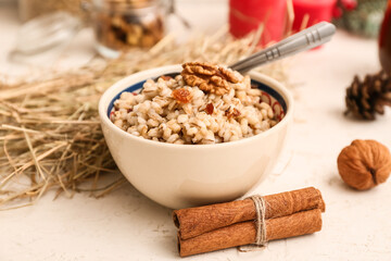 Bowl of traditional Ukrainian Kutya dish and cinnamon on white background