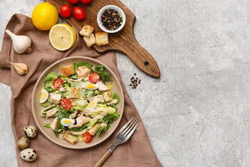 Plate with tasty chicken Caesar salad and ingredients on grey background
