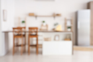 Wooden table with candles in modern kitchen. Blurred view