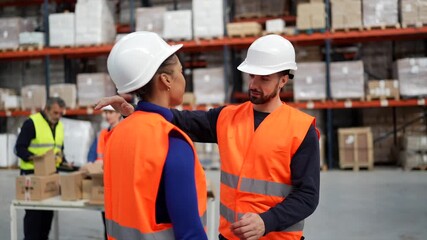 Diverse warehouse colleagues comforting each other with a hug - Powered by Adobe
