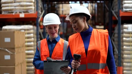 Two women warehouse workers managing inventory with scanners - Powered by Adobe