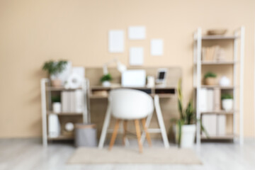 Stylish comfortable workplace with laptop and tablet computer in modern office. Blurred view