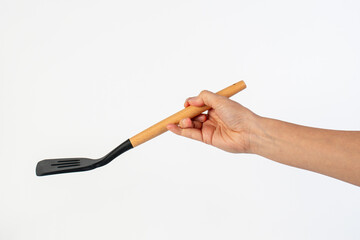 Hand holding kitchen utensils on white background