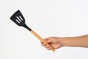 Hand holding kitchen utensils on white background