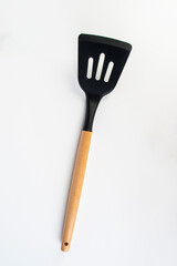 Hand holding kitchen utensils on white background