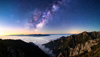 A panoramic view of mountains topped with clouds under a vibrant, star-filled night sky