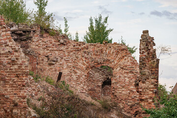 The ruins of an old brick fortress with green grass growing on it