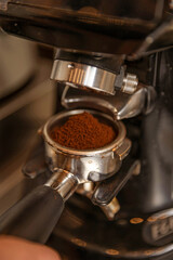 Close-up of ground coffee in espresso machine portafilter.