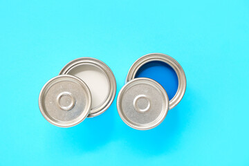 Cans of different paint on blue background