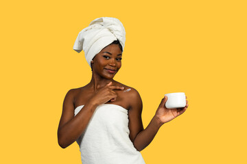 Black woman applying body lotion for skin care