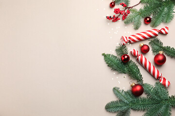 Fir tree branches, candies and Christmas decor on light background, flat lay. Space for text