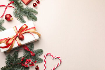Fir tree branches, gifts, candy canes and Christmas decor on light background, flat lay. Space for...