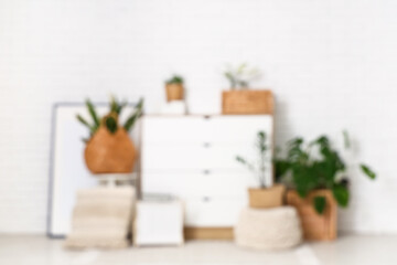 Blurred view of room with commode and green plants in wicker baskets