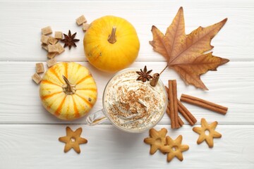 Fototapeta premium Tasty pumpkin latte with whipped cream in glass cup, cookies and ingredients on white wooden table, flat lay