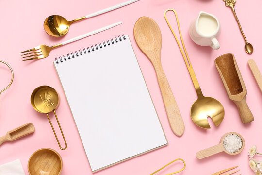 Composition with blank recipe book and different kitchen utensils on pink background