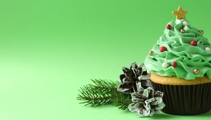 Christmas tree shaped cupcake and festive decor on green background, closeup. Space for text