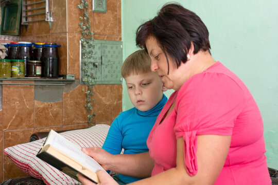 Grandmother reading to grandson at home, fostering learning, quality time and creating family bonds through storytelling and shared experiences.