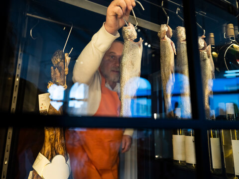 Chef arranging fresh fish in cooler during cooking class in kitchen