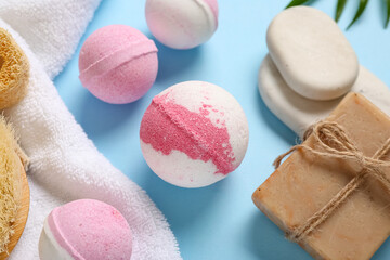 Composition with bath bombs, soap bar, spa stones and towel on color background