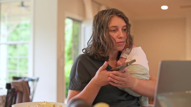 mother reviewing schedule on laptop while cradling baby, thoughtful expression, papers and plate on table, warm interior, planning appointments and prioritizing care in busy home life