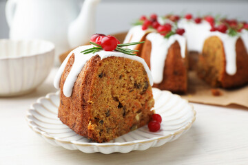 Slice of tasty Christmas cake with cranberries served on light wooden table, closeup