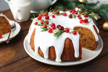 Tasty cake with cranberries and Christmas decor on wooden table, closeup