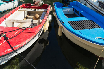 Obraz premium Two colorful small boats, red and blue, moored in a picturesque port in the Calanques National Park, France.