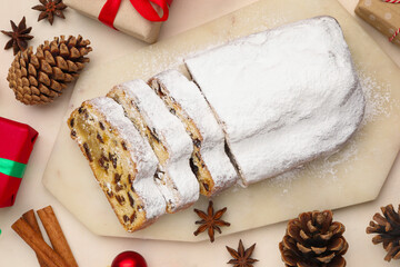 Cut traditional Stollen cake, gifts and Christmas decor on white table, flat lay